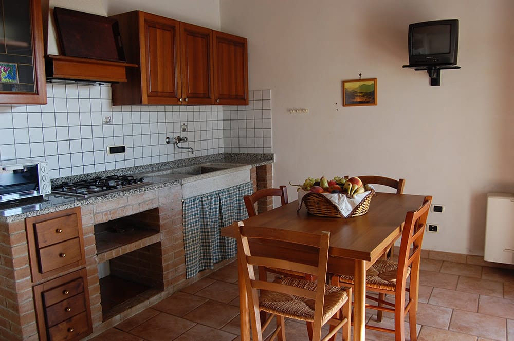 Angolo cottura in muratura e tavolo da pranzo